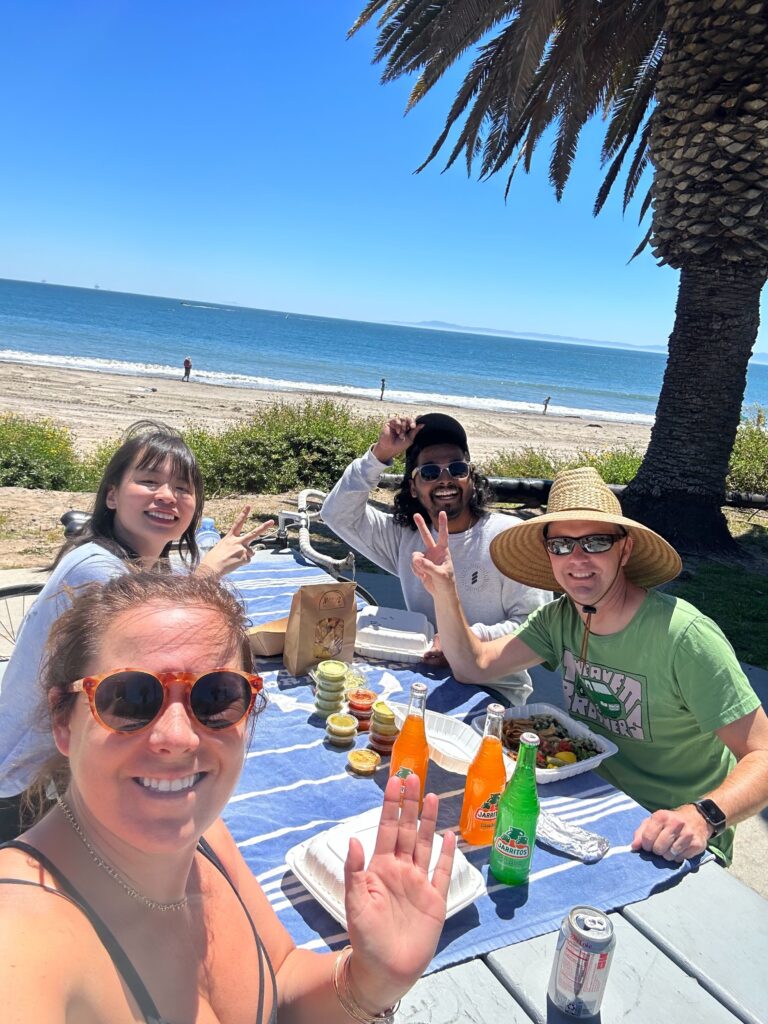 Four people having a picnic on the beach.