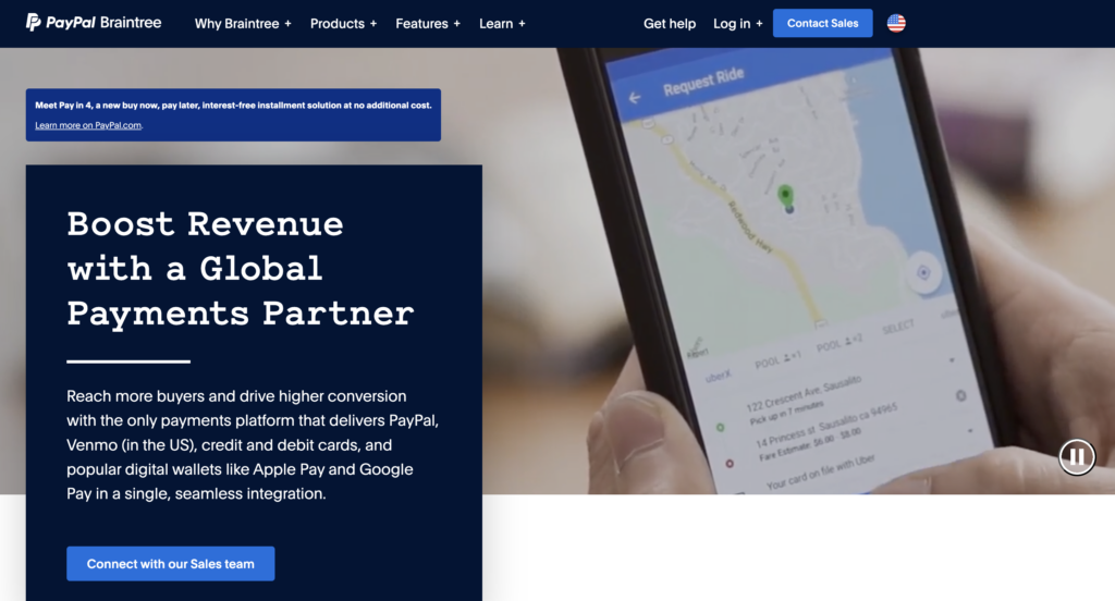 Screenshot of international payment gateway Braintree's homepage, with a close up photo of a hand holding a smartphone on the right and a dark blue block with white text on it on the left.