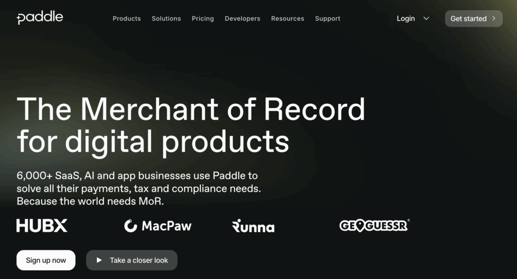Screenshot of Stripe alternative Paddle's homepage, black with white text and yellow blurs with white customer logos.