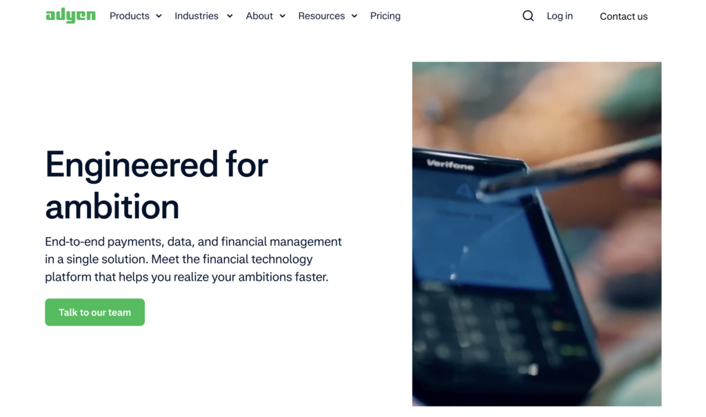 Screenshot of Digital River alternative Adyen's homepage, white background with black or green text and a close-up image of a small digital device and stylus.