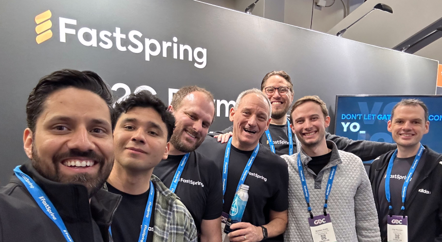 Seven members of the FastSpring team smiling for a group selfie in FastSpring's GDC 2025 booth.